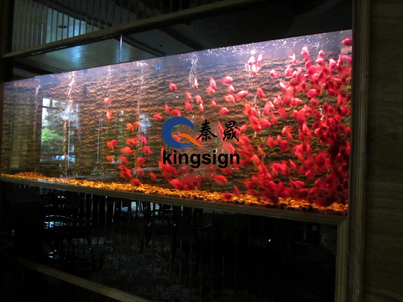 ¿Por qué se recomienda utilizar material acrílico para tanques de peces de la fortuna a gran escala?